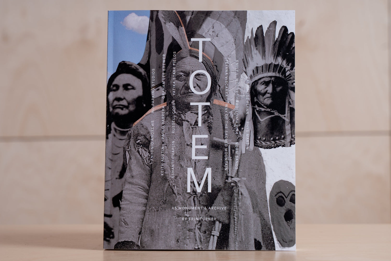 Book titled 'TOTEM' with cover art featuring Native American figures on a wooden surface.